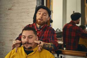 Klient während Bart Rasieren im Barbier Geschäft foto