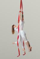 schön Mädchen und ein sportlich Mann im ein Weiß Sport Anzüge sind durchführen ein akrobatisch Elemente im ein Studio. foto