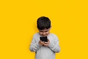 Freizeit-, Kinder-, Technologie- und Menschenkonzept - lächelnder Junge mit Smartphone oder Spiel zu Hause kopieren foto