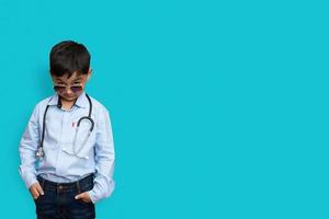 lächelnder kleiner Junge mit Stethoskop und Brille isolierter Hintergrund mit Kopienraum foto