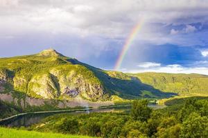 bunter regenbogen über dem see vangsmjose und bergpanorama norwegen. foto