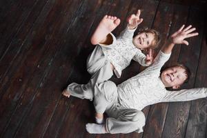 zwei Kinder, Bruder und Schwester im Pyjama spielen zusammen foto