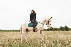 junges hübsches Mädchen - Reiten, Pferdesport im Frühling foto