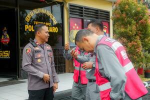 kuaro Kalimantan Timur, Indonesien 19 Januar 2024. ein Polizei Offizier ist interagieren mit Unternehmen Angestellte foto