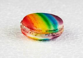 Nahansicht von ein köstlich und bunt regenbogenfarben Macaron platziert separat auf ein Weiß Oberfläche, Erstellen ein schön Betrachtung foto