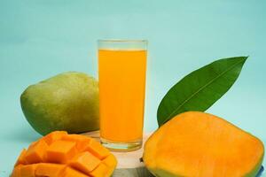 Mango trinken auf runden Tablett mit Mango Obst auf Blau Hintergrund foto