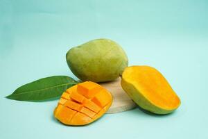 frisch Mango Obst mit Würfel Scheibe mit Gelb Fleisch Innerhalb isoliert auf Schneiden Tafel Blau Hintergrund enthalten Vitamin c foto