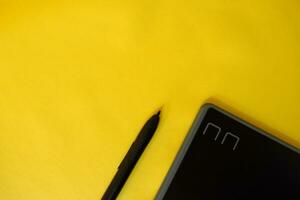 eben legen von abgeschnitten Grafik kreativ Stift Tablette, mit Kopieren Raum auf Gelb Hintergrund foto