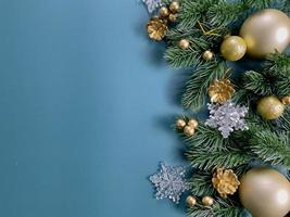Weihnachtsschmuck, Kiefernblätter, goldene Kugeln, Schneeflocken, goldene Beeren auf blauem Hintergrund