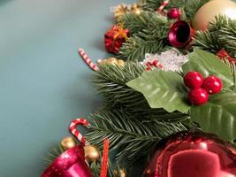 Weihnachtsschmuck, Kiefernblätter, goldene Kugeln, Schneeflocken, rote Beeren und goldene Beeren auf blauem Hintergrund foto