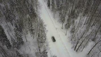 Antenne Aussicht von Panzer Fahren durch das Winter Wald. Schlacht Panzer im das Wald. Panzer unter das Schnee foto