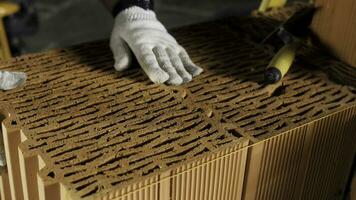 industriell Maurer Arbeiter Platzierung Ziegel auf Zement während Gebäude Wände. Lager Filmaufnahme. schließen oben von ein Mann im schützend Handschuhe Putten schwer Backstein Block zu bilden ein Schicht. foto