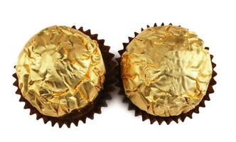 zwei Schokolade Süßigkeiten im ein golden vereiteln Verpackung isoliert auf ein Weiß Hintergrund. Elite Pralinen. foto