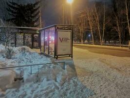 Russland, das Stadt von Twer, ein Bus halt mit ein Werbung Inschrift Präsidentschaftswahl Wahlen im Russland auf März 15-17, 2024, Abend Dezember 27, 2023, Winter, Nein Menschen foto
