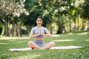 Porträt von jung Frau üben Yoga im garten.weiblich Glück. im das Park verschwommen Hintergrund. foto