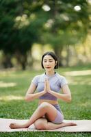 Porträt von jung Frau üben Yoga im garten.weiblich Glück. im das Park verschwommen Hintergrund. foto