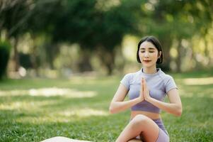 Porträt von jung Frau üben Yoga im garten.weiblich Glück. im das Park verschwommen Hintergrund. foto