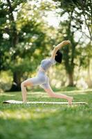 Porträt von jung Frau üben Yoga im garten.weiblich Glück. im das Park verschwommen Hintergrund. foto