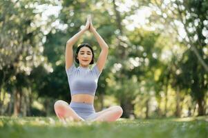 Porträt von jung Frau üben Yoga im garten.weiblich Glück. im das Park verschwommen Hintergrund. foto