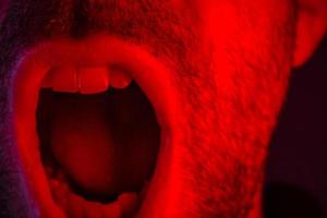 Makro Nahaufnahme auf Mann schreien mit weit geöffnetem Mund foto
