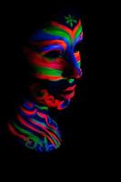 Frau mit Make-up-Kunst aus leuchtendem UV-fluoreszierendem Puder foto