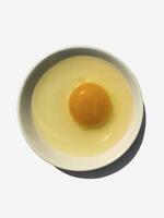 Hähnchen Ei Eigelb auf ein Weiß Teller auf ein Weiß Hintergrund. foto