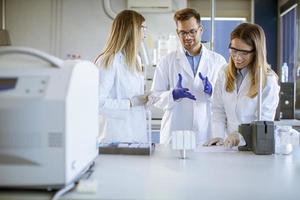 Forscher in Arbeitsschutzkleidung, die im Labor stehen und flüssige Proben an Ionenchromatographiegeräten analysieren