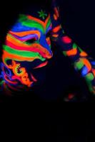 Frau mit Make-up-Kunst aus leuchtendem UV-fluoreszierendem Puder foto