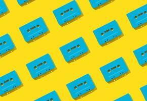 Muster gemacht mit retro Blau Audio- Kassette Bänder auf Gelb Hintergrund. kreativ Konzept von retro Technologie. 80er Jahre ästhetisch. Jahrgang Audio- Kassette Band Muster Idee. retro Nostalgie. eben legen. foto