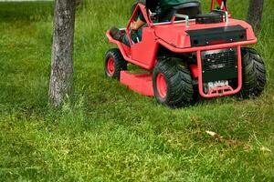 Fachmann Gras Schneiden auf Rasenflächen mit ein Mini Traktor Rasen Mäher. foto