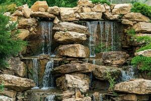 Landschaft Design, ein Damm mit ein Kaskade von Wasserfälle im das bilden von natürlich Felsen foto