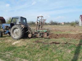 Traktor pflügt das Land auf dem Land foto