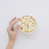 Draufsicht von Hand gesalzenes Popcorn pflücken foto