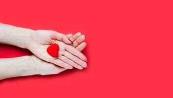Frauen Hände hält rot Herz auf rot Hintergrund. Nahansicht. oben Sicht. Platz zum Text. foto