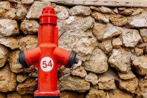 Feuer Hydrant in der Nähe von Jahrgang Stein Mauer foto