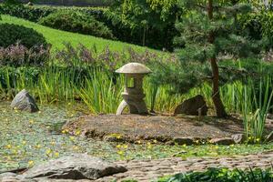 Stein Laterne auf ein klein Insel im das Mitte von ein Teich im ein japanisch Garten foto