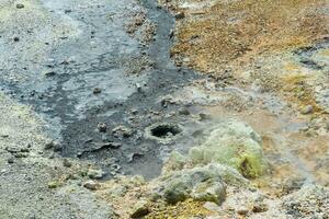 Sieden Fumarolen und Schwefel Einlagen beim das hydrothermal Auslauf auf das Ufer von das heiß See im das Caldera von das golovnin Vulkan auf das Insel von Kunaschir foto