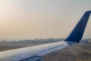 Flugzeugflügel auf der Landebahn des Flughafens Ben Gurion bei Sonnenaufgang foto