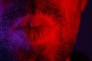 Makro Nahaufnahme eines Mannes mit verführerischem Gesichtsausdruck zog seine Lippen, um einen Kuss zu geben foto