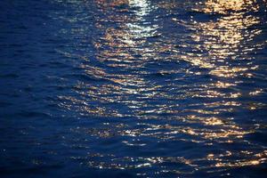 Lichtstrahlen auf dem Wasser in der Dämmerung foto