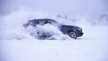 Winter Fahren. Blau Auto fährt durch eisig Spur auf Schnee bedeckt See beim Winter. Sport Auto Rennen auf Schnee Rennen Spur im Winter. Fahren ein Rennen Auto auf ein schneebedeckt Straße foto