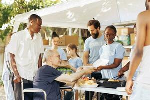 vielfältig Einzelpersonen spenden kostenlos Essen zu Bedürftige Angebot Portion Hand im Kampf gegen Hunger und Armut. Freiwillige zur Verfügung stellen Unterstützung zu obdachlos Arm und deaktiviert präsentieren wohltätig Bemühungen. foto