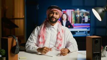 Porträt von lächelnd arabisch Mann beschäftigt, verlobt im E-Learning Webinar Video Konferenz mit Lehrer. Mitte östlichen Schüler im online Videoanruf Gruß Tutor, bezahlen Beachtung zu seine Wörter und nehmen Anmerkungen foto