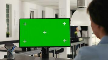 Büro Manager Verwendet grüner Bildschirm auf pc und Arbeiten mit isoliert Monitor Anzeige zum Geschäft Entwicklung. Frau suchen beim Computer zeigen leer Chromakey Layout auf Schreibtisch. Handheld Schuss. foto