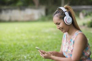 asiatische Frau hört Lieblingsmusik über Kopfhörer. glückliche Zeit und entspannen.