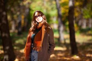 Porträt einer schönen jungen Frau mit Sonnenbrille im Herbstwald foto