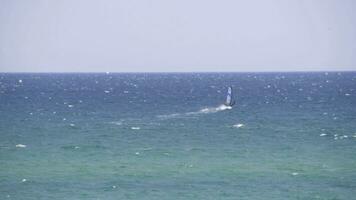 Windsurfer Reiten das Wellen im das Meer. Schuss. Windsurfer im das Meer, Mann auf Windsurfen erobern das Wellen, genießen extrem Sport, aktiv Lebensstil, glücklich Sommer- Ferien foto