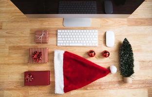 rote Geschenkbox in Weihnachtsferien im Büro mit Weihnachtsdekoration auf dem Tisch. foto