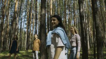 freunde abspielen Volleyball im Wald. Lager Filmaufnahme. Gruppe von Menschen abspielen Ball Stehen im Kreis im Wald auf Sommer- Tag. freunde entspannen im Natur im sonnig Wetter foto