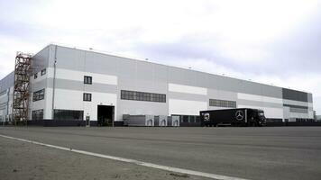 oklo - - Norwegen, 20.11.2021. Neu Mercedes Benz Ware Haus mit ein geparkt LKW. Szene. groß Ladung Auto Stehen durch ein Neu Gebäude auf wolkig Himmel Hintergrund. foto